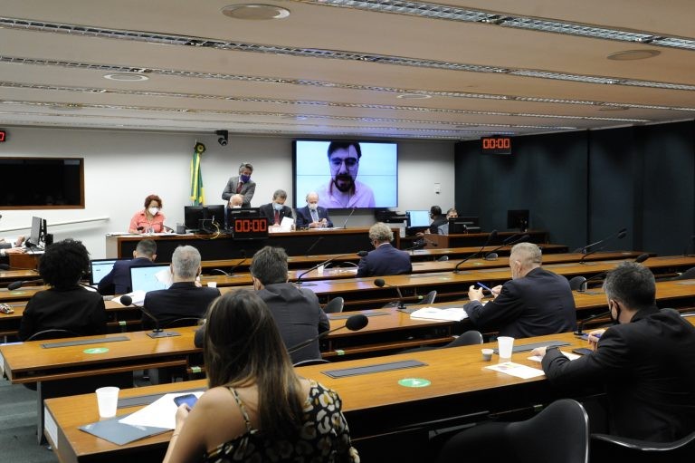 Para Guilherme Melo (no telão), alta de juros vai reduzir o crescimento - (Foto: Gustavo Sales/Câmara dos Deputados)