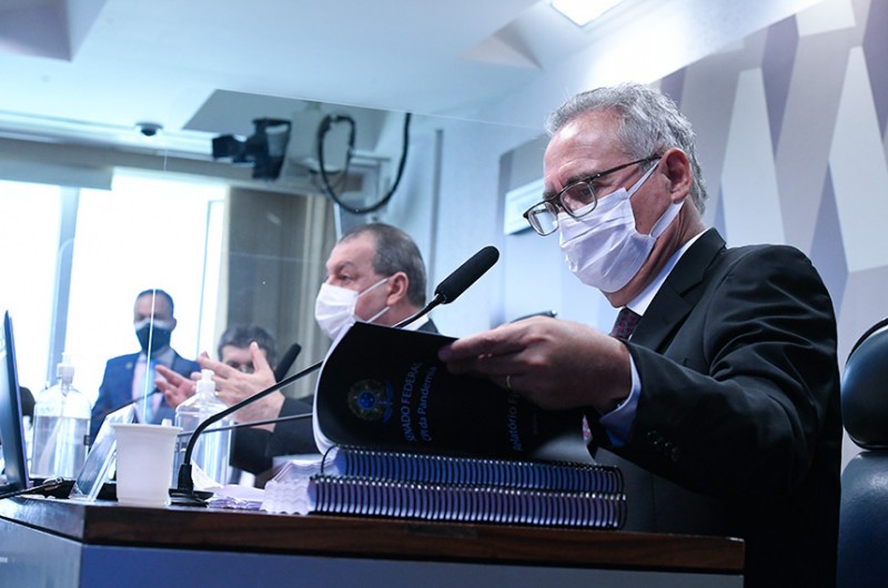 Renan lê o relatório ao lado do presidente Omar Aziz e do vice-presidente da CPI, Randolfe Rodrigues - Edilson Rodrigues/Agência Senado